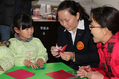  苏宁电器枣庄店店长董莉莉和残疾儿童一起做手工