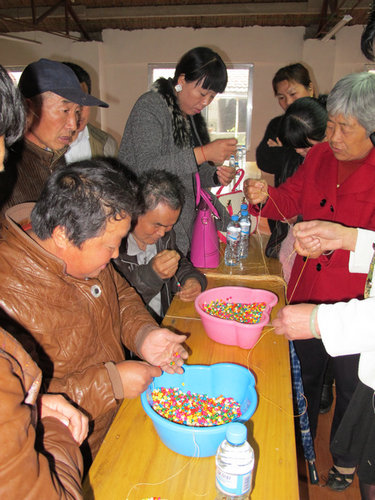 图为：学员们学习串珠