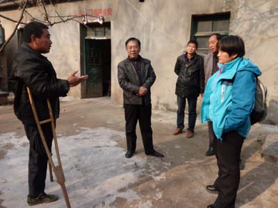 图为在残疾人孙业玉家中调研