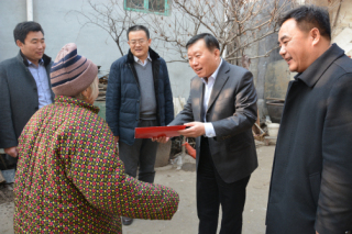 图为刘书记为困难残疾人送上慰问金