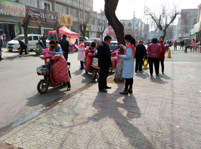 图为工作人员上街发放宣传单