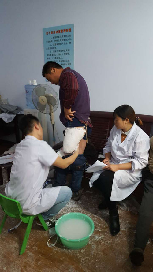 图为工作人员为残疾人取假模