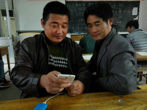 图为参训学员张言江（左）在帮助其他学员学习