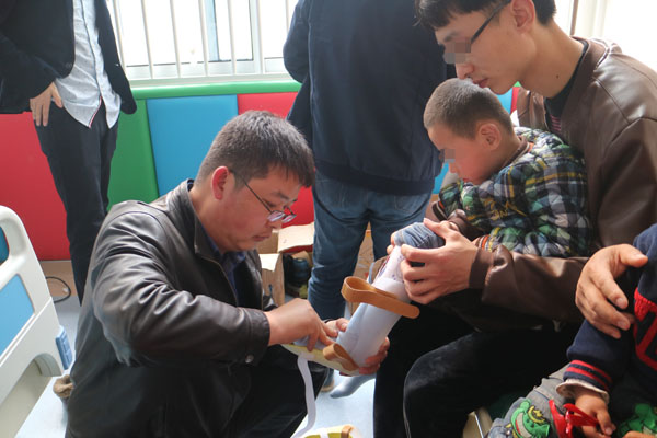 图为专家正在为残疾儿童安装矫形器