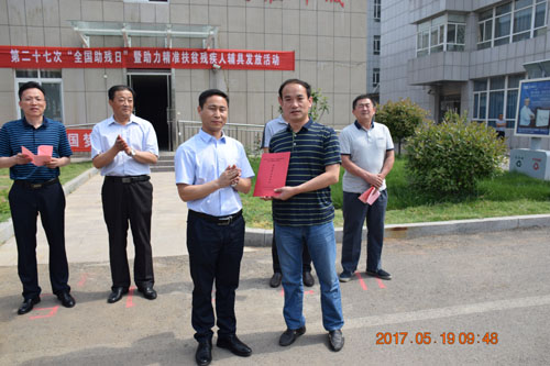 图为余副区长为镇（街）分管领导发放残疾人辅具名册