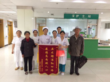 图为受助群众为医务人员送锦旗