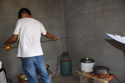 图为考察组在测量厨房多功能橱柜安装尺寸