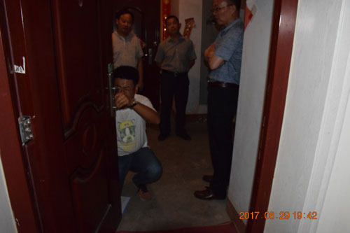 图为考察组在测量可视对讲机安装尺寸