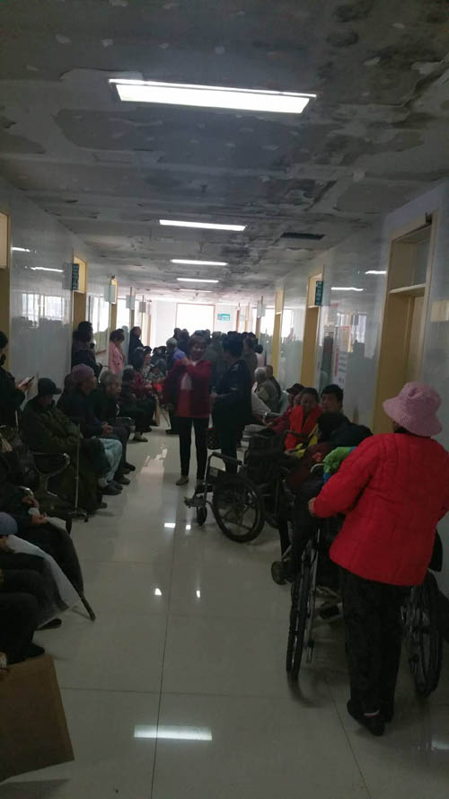 图为等候残疾鉴定的残疾人及家属