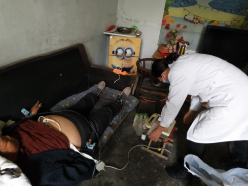义务人员正在为行动不便的残疾人入户开展康复服务