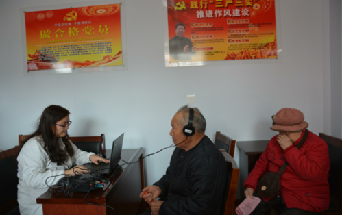 图为专业人员在辅导居民做耳保健操