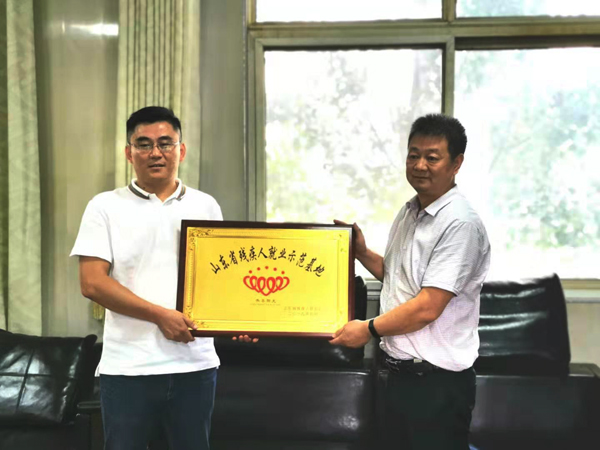 图为刘光顺副部长向滕州市中福田陈洗煤有限公司颁发了“山东省残疾人就业示范基地”奖牌。