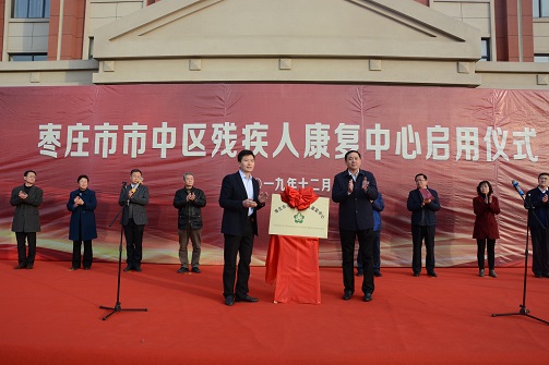 图为市残联理事长祝世峰与市中区委书记王辉为市中区残疾人康复中心启用仪式进行揭牌。