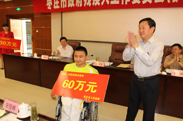图为市领导为残奥冠军颁发奖金