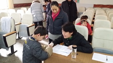 图为枣庄市残联工作人员登记残疾儿童信息