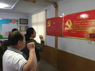 图为鲜红的党旗下，新党员入党宣誓、老党员重温入党誓词。