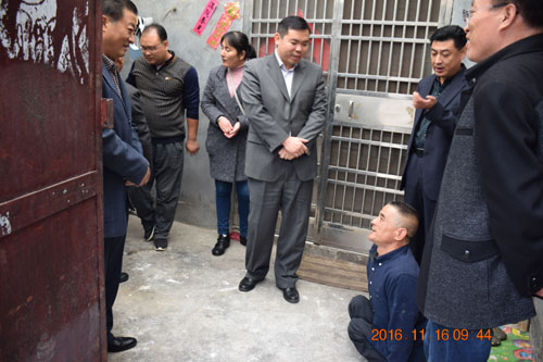 图为检查组在坛山办事处肢体残疾人曹怀印家中检查低厨柜、厨具改造