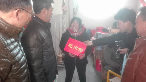 图为王振义副理事长为建档立卡贫困残疾人送去慰问金