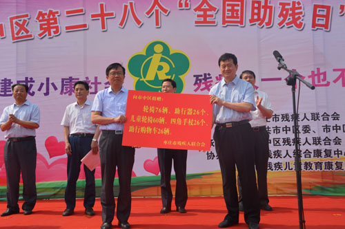 图为市残联理事长王国华（右）向市中区副区长阚刚（左）捐赠