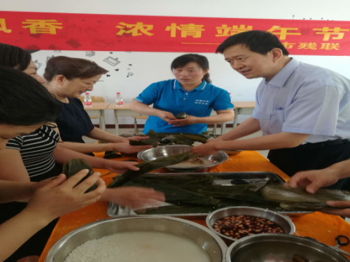 枣庄市残联理事长王国华和大家一起包粽子