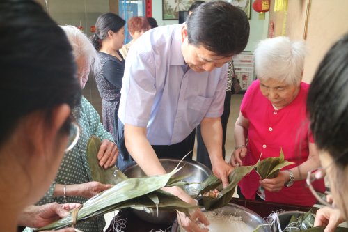 枣庄市残联理事长王国华与敬老院老人一起包粽子