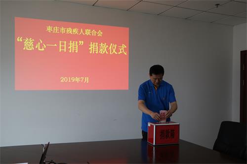 图为市残联党组书记、理事长王国华捐款