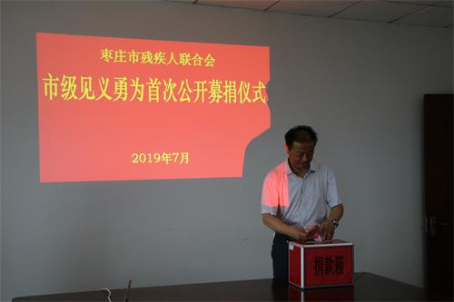 图为市残联副理事长张光忠捐款