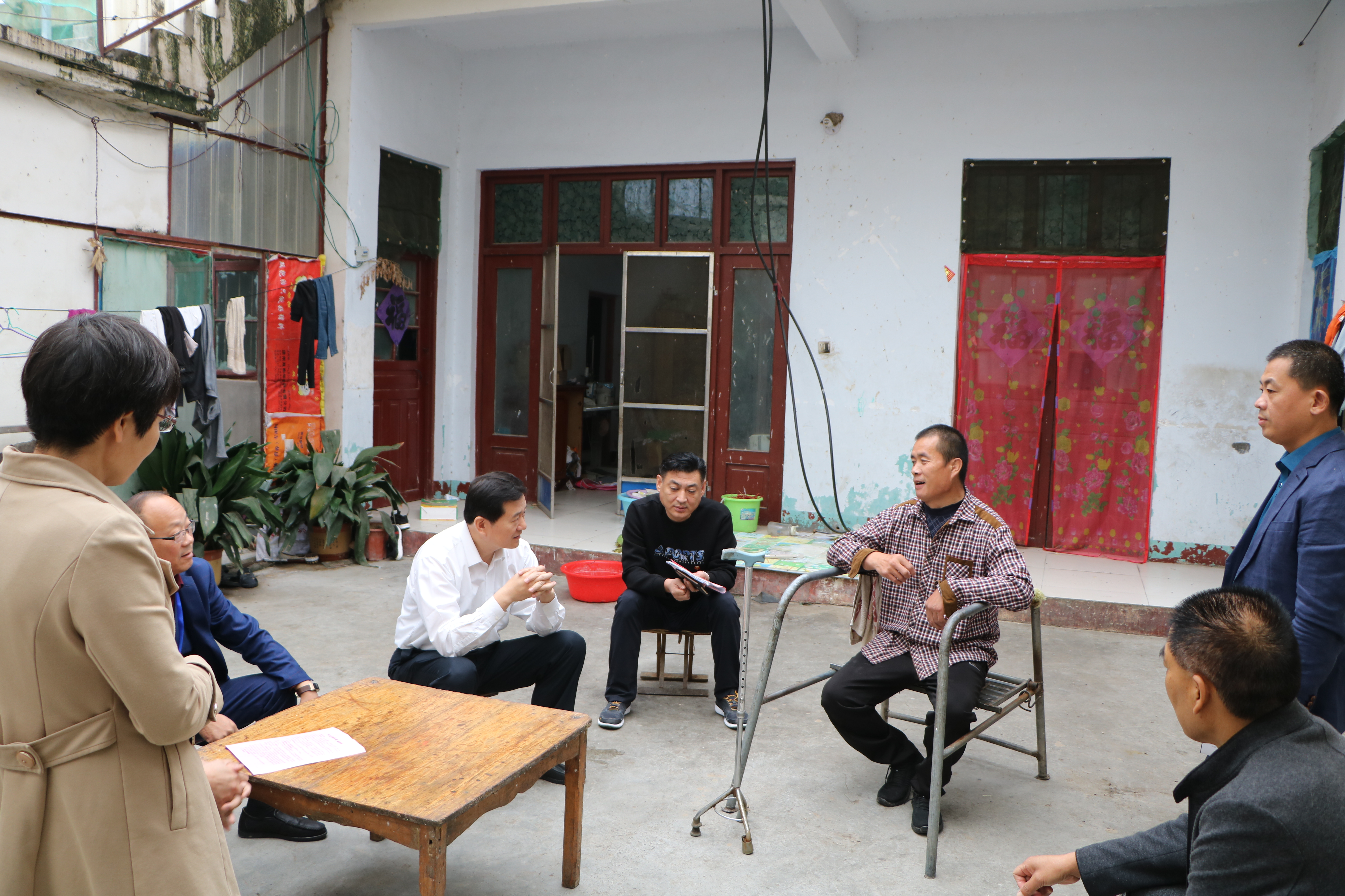 图为市残联理事长王国华对建档立卡残疾人户进行实地走访。
