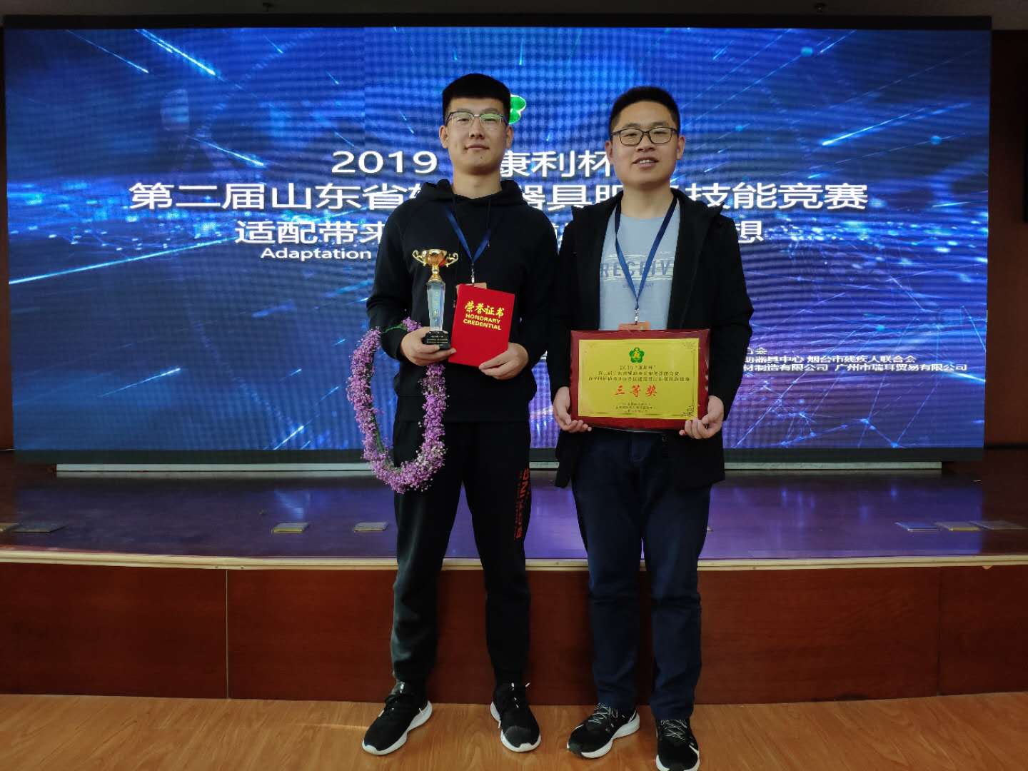 图为枣庄市代表参加辅助器具服务技能竞赛人员手拿奖杯和证书获奖留念。