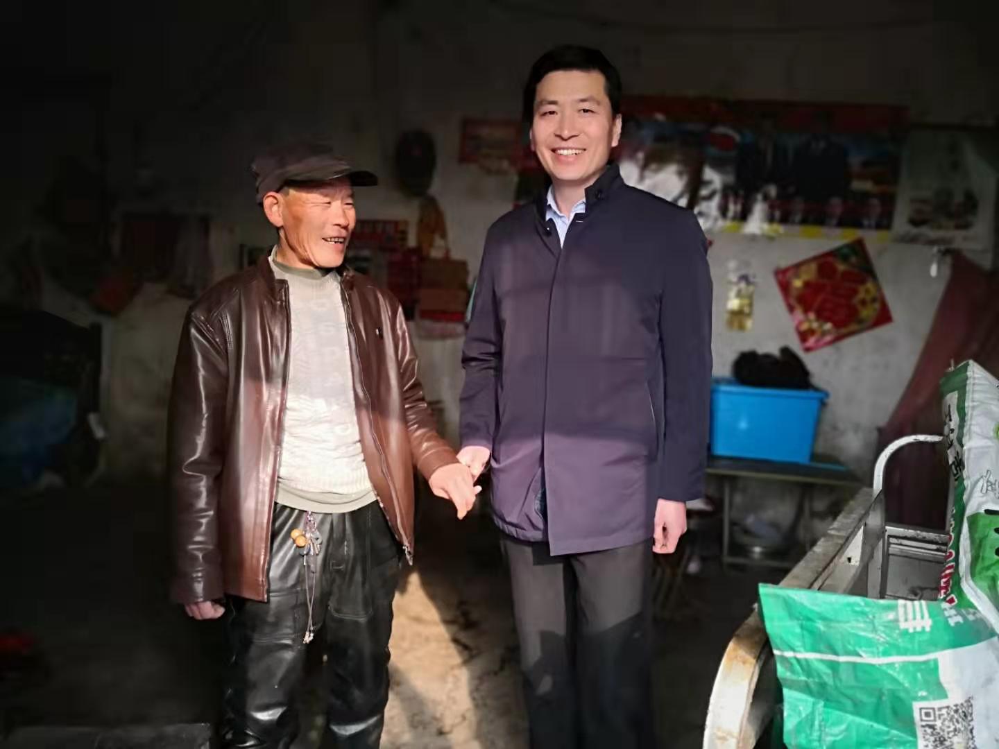 图为祝世峰理事长同贫困户交流。
