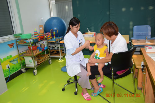 图为脑瘫儿童康复治疗师魏永彩在帮助脑瘫儿童进行作业训练